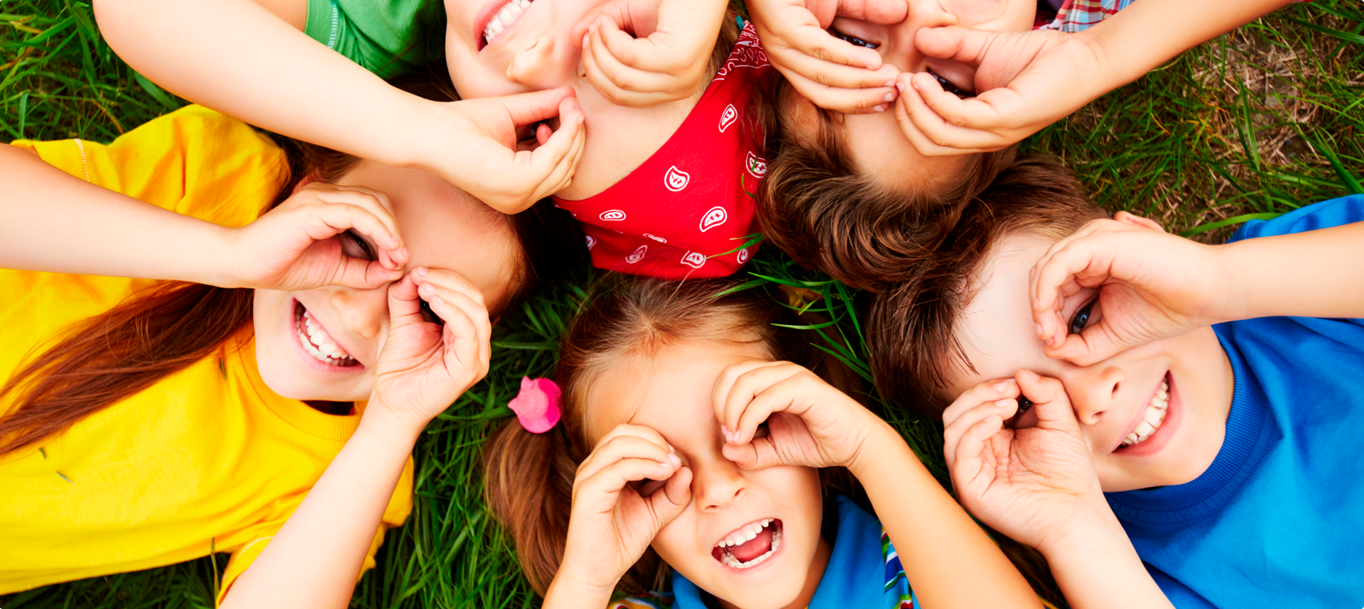 Niños jugando acostados en el pasto